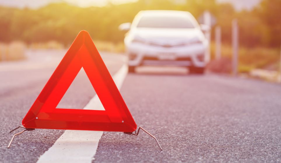 triangulo de emergencia posicionado para cambiar rueda en carretera