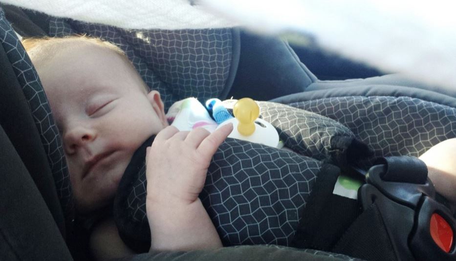 Bebe dormido en el coche con la silla de seguridad.