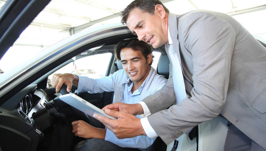 Hombre mirando un coche antes de comprar.