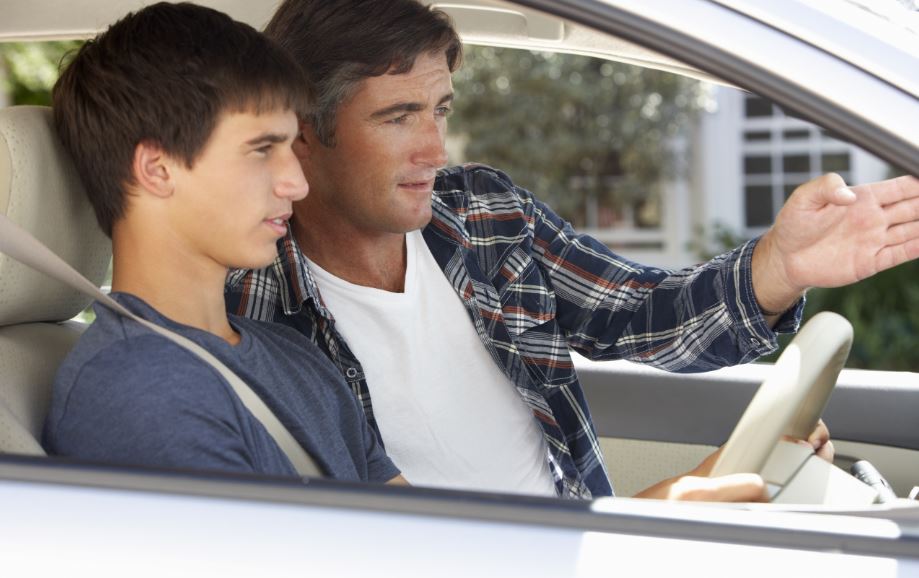 Un padre enseñando a su hijo a conducir.