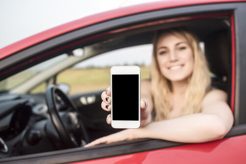 Mujer mostrando su carné de conducir digital desde el coche.